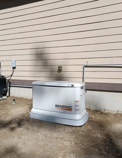 Generac standby generator installed beside a home near the outdoor HVAC unit