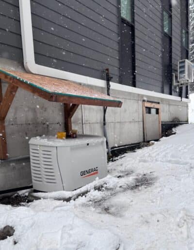 Generac standby generator installed beside a home in snowy conditions